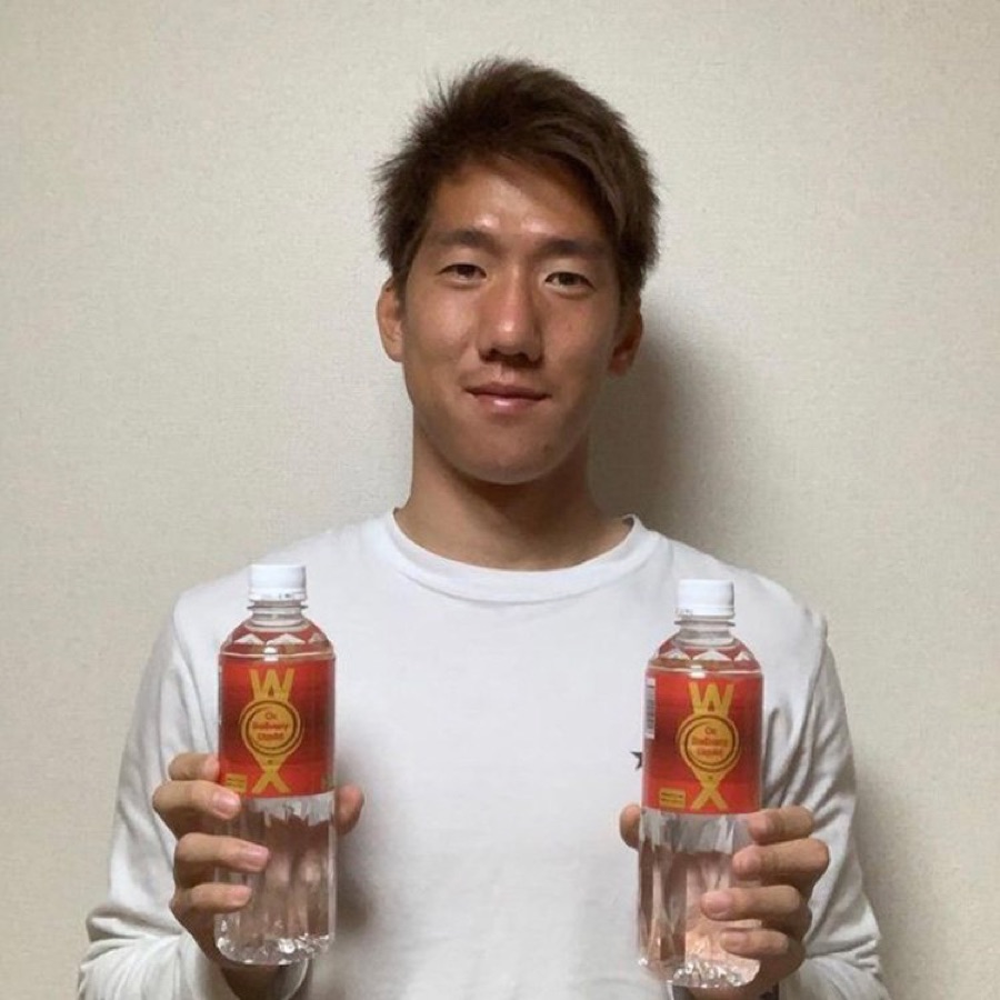 Professional football player holding two bottles of WOX