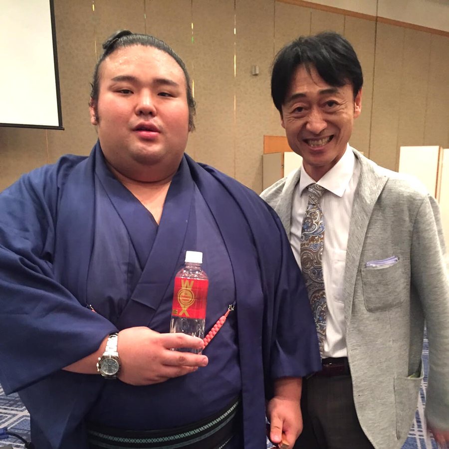 Sumo wrestler holding a bottle of WOX
