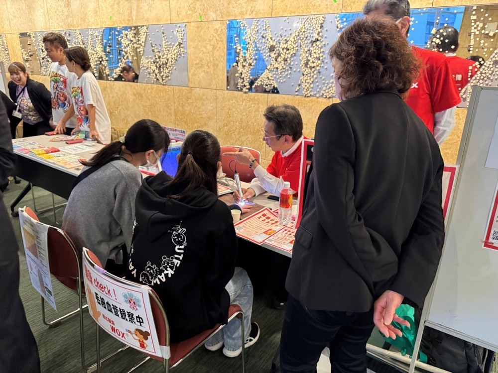 Visitors talking with staff at the WOX booth